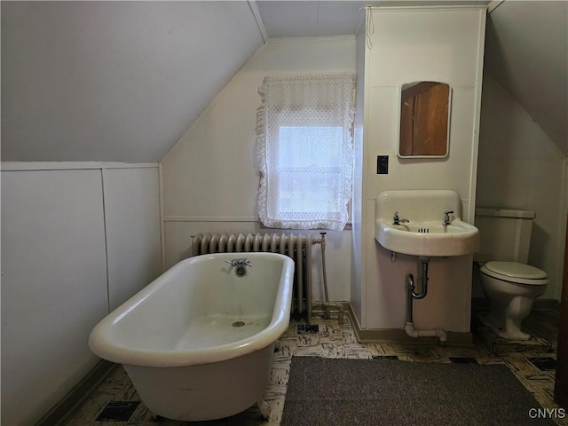 bathroom with a bathing tub, toilet, vaulted ceiling, and radiator