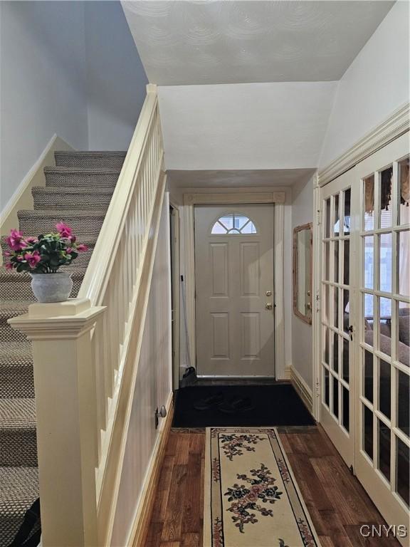 interior space with french doors, dark wood-type flooring, and vaulted ceiling