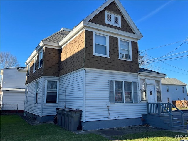 view of front of house with a front lawn and roof with shingles