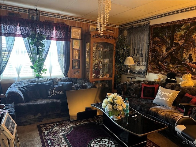 carpeted living room featuring wooden walls