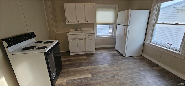 kitchen with baseboards, light countertops, wood finished floors, white cabinets, and white appliances