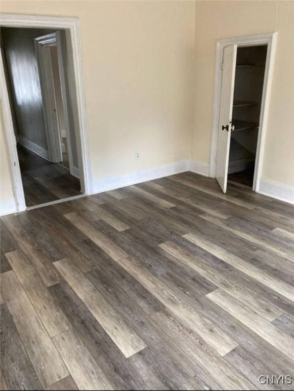 unfurnished bedroom featuring a closet, baseboards, and wood finished floors