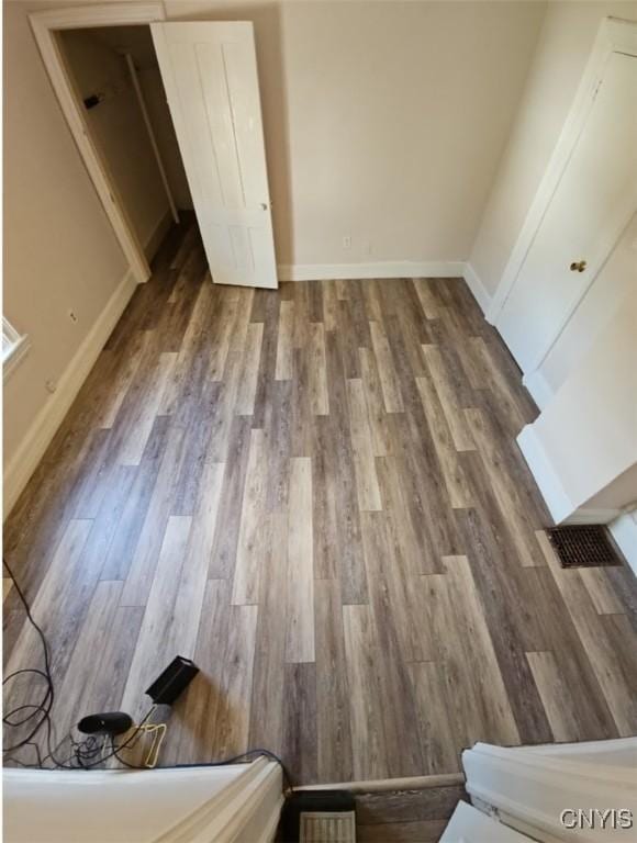 unfurnished bedroom featuring visible vents, baseboards, and wood finished floors