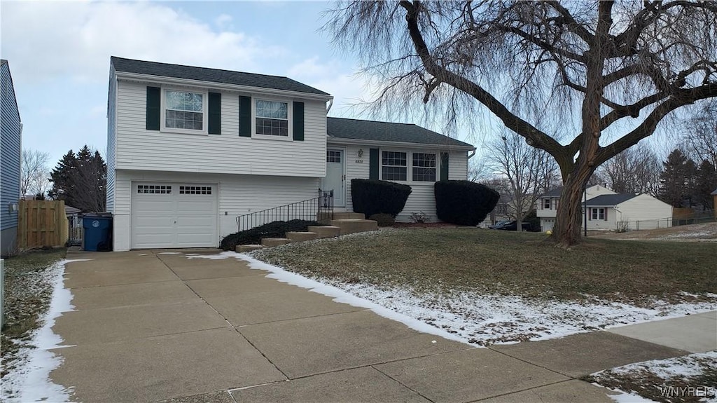 split level home with a lawn and a garage