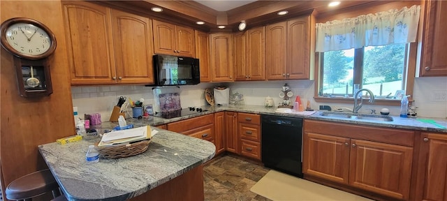 kitchen with light stone counters, sink, and black appliances