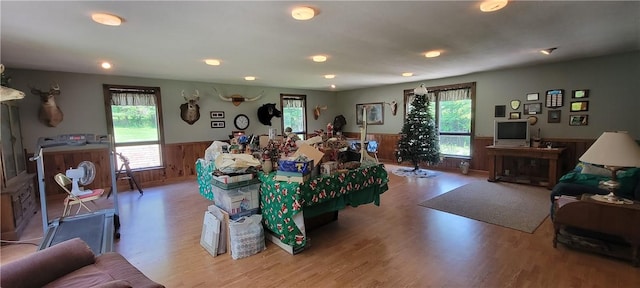 living room with light hardwood / wood-style floors, a healthy amount of sunlight, and wood walls