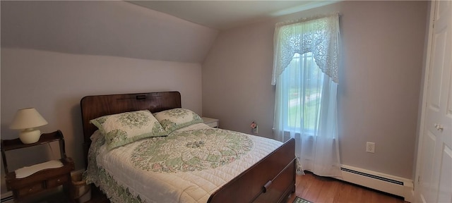 bedroom with vaulted ceiling, wood-type flooring, and a baseboard radiator