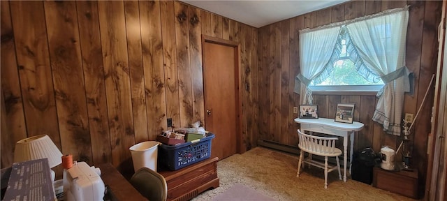 interior space with wood walls, carpet, and a baseboard heating unit