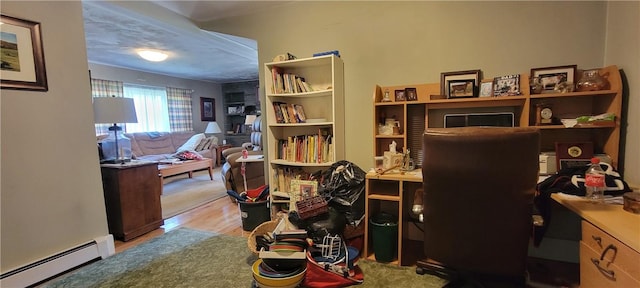 home office with a baseboard radiator and light hardwood / wood-style flooring