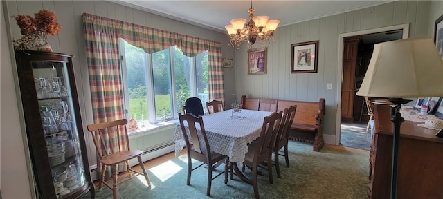 carpeted dining area featuring crown molding and an inviting chandelier