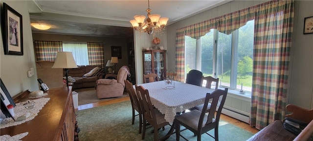 dining room featuring plenty of natural light, ornamental molding, a chandelier, and light hardwood / wood-style flooring