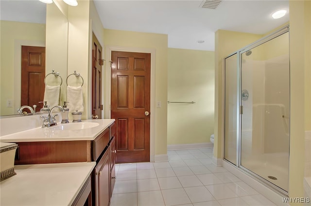 bathroom featuring tile patterned flooring, vanity, toilet, and walk in shower