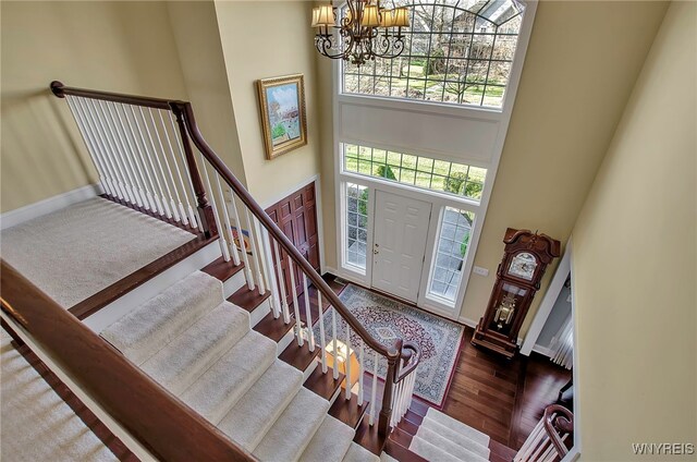 foyer entrance featuring dark hardwood / wood-style floors, a high ceiling, and an inviting chandelier