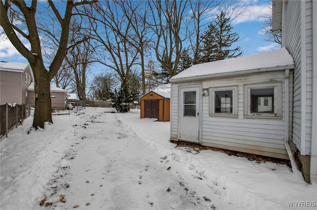 yard covered in snow featuring a storage shed