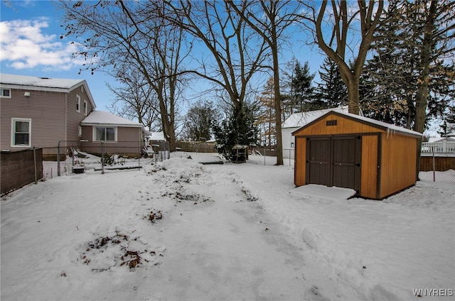 yard layered in snow featuring a storage unit