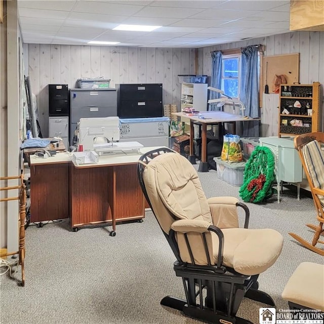 carpeted office with a drop ceiling and wood walls