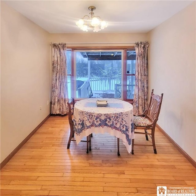 dining room featuring light wood-type flooring and a chandelier