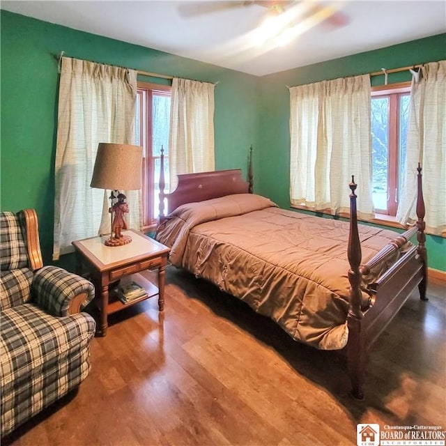 bedroom featuring multiple windows, ceiling fan, and hardwood / wood-style flooring