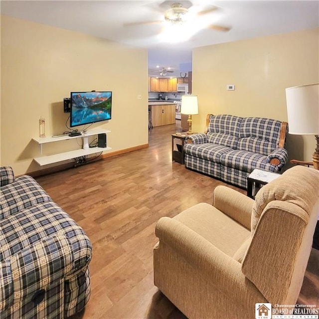 living room featuring ceiling fan and light wood-type flooring