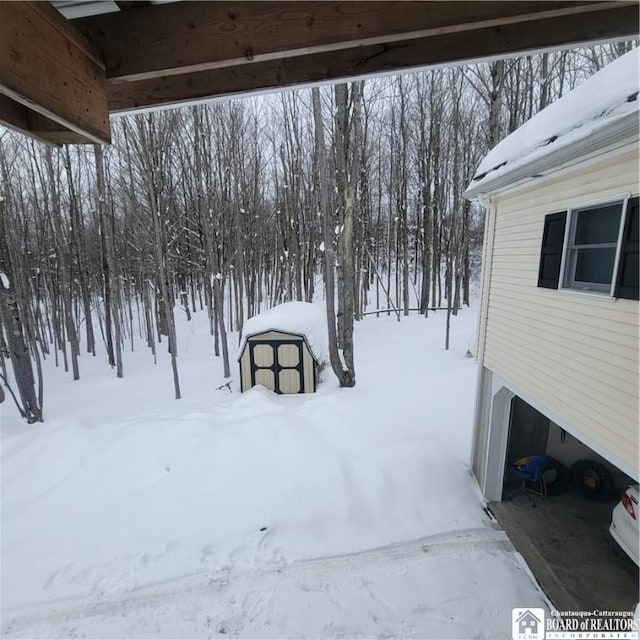 yard covered in snow featuring a garage