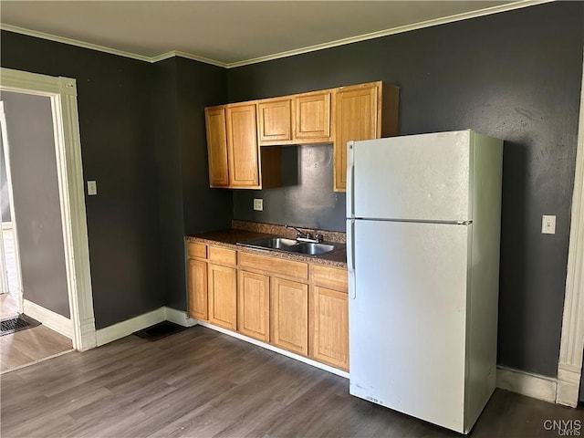 kitchen with sink, white fridge, dark hardwood / wood-style floors, and ornamental molding