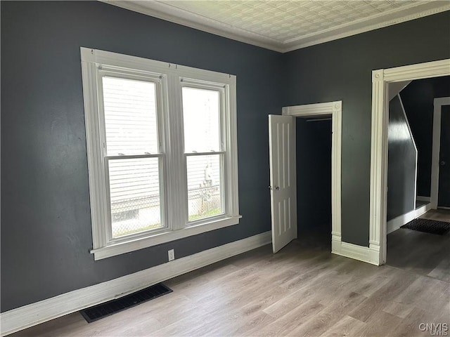 unfurnished bedroom with wood-type flooring and crown molding