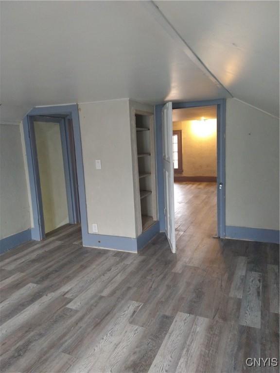 additional living space featuring hardwood / wood-style floors and vaulted ceiling