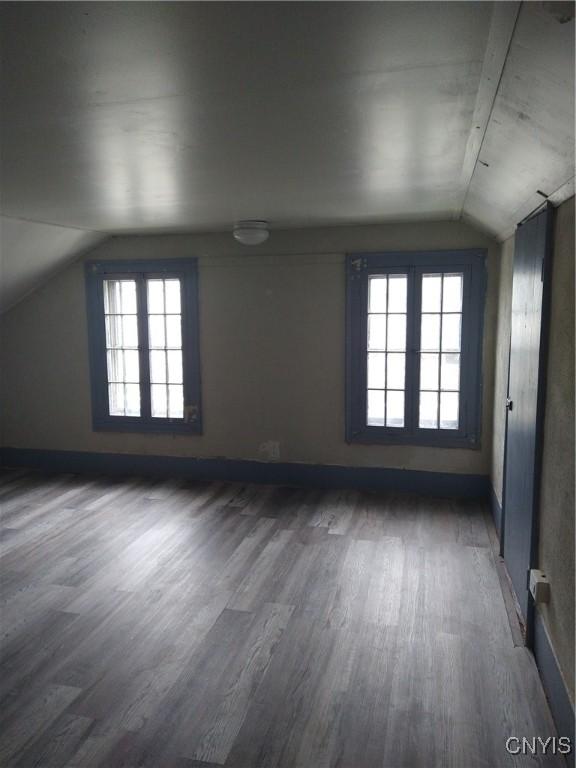 bonus room with dark hardwood / wood-style flooring, a wealth of natural light, and vaulted ceiling