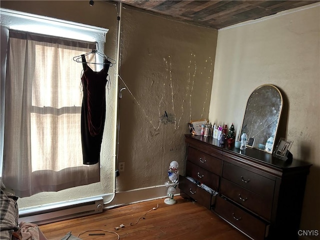 interior space with hardwood / wood-style flooring and a baseboard heating unit