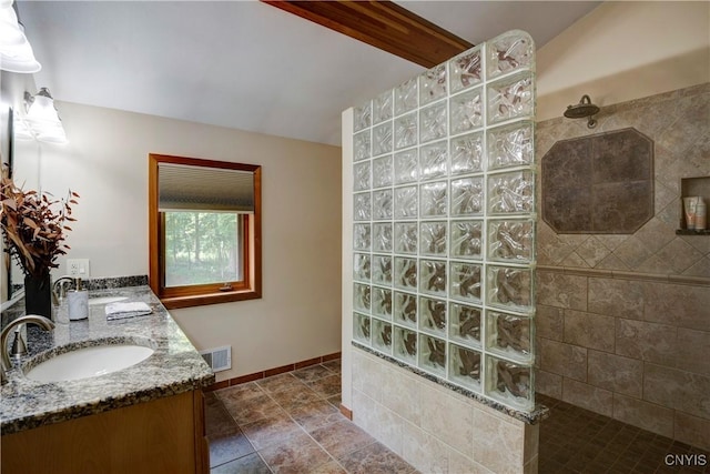 bathroom with vanity and tiled shower