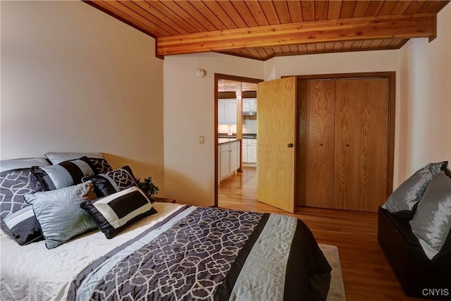 bedroom with beamed ceiling, light wood-type flooring, and wood ceiling