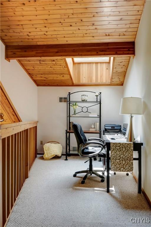 carpeted office with beamed ceiling, a skylight, and wood ceiling