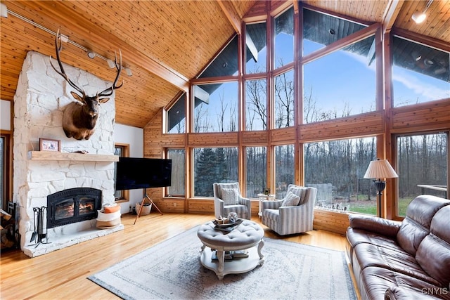 living room featuring beam ceiling, wood-type flooring, a healthy amount of sunlight, and high vaulted ceiling