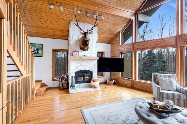 living room with a wealth of natural light, hardwood / wood-style floors, and high vaulted ceiling