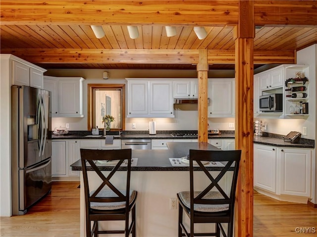 kitchen with beam ceiling, light hardwood / wood-style floors, white cabinets, wood ceiling, and appliances with stainless steel finishes