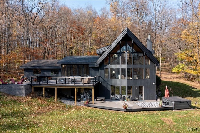 rear view of property featuring a lawn and a wooden deck