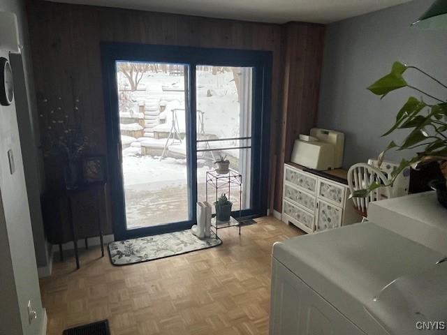 entryway with wooden walls and light parquet flooring