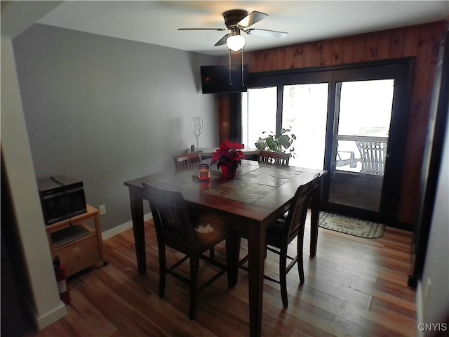 dining space featuring wood-type flooring and ceiling fan