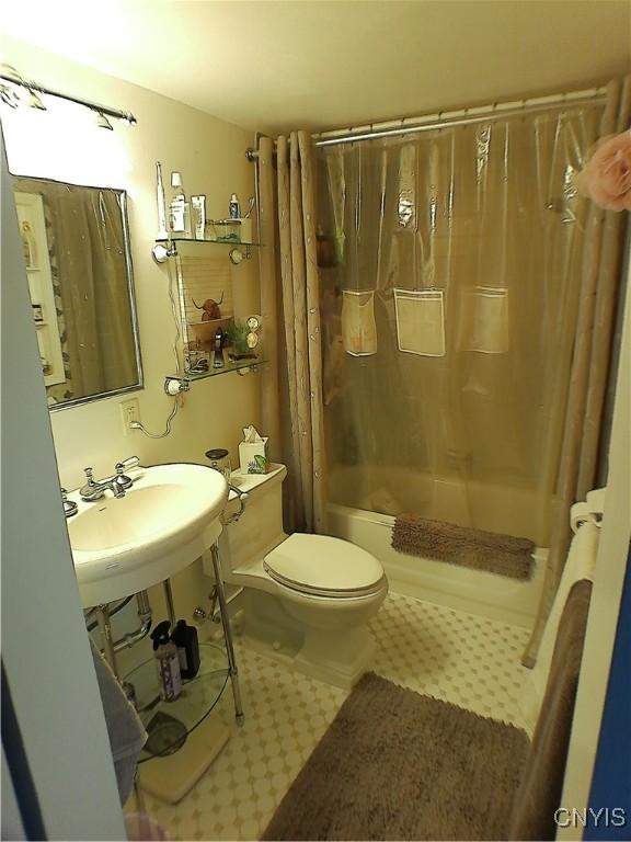 full bathroom with sink, shower / tub combo with curtain, and toilet