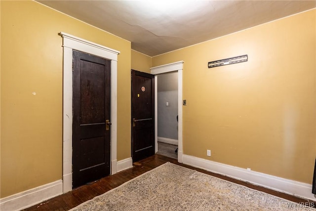 unfurnished bedroom featuring dark wood-type flooring and a closet