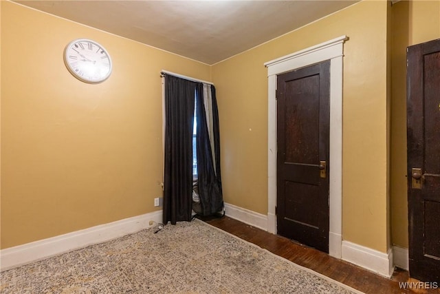 empty room with dark hardwood / wood-style flooring