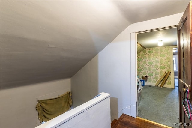 hallway with vaulted ceiling and carpet