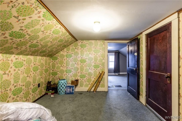 bonus room with dark colored carpet and lofted ceiling