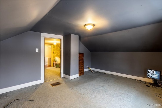 additional living space with vaulted ceiling and light colored carpet