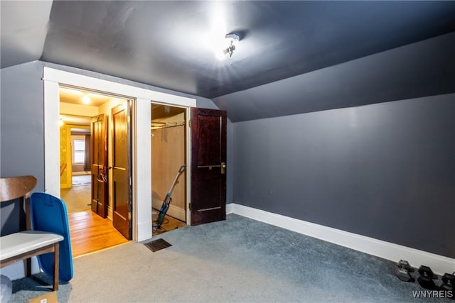 additional living space with vaulted ceiling and carpet