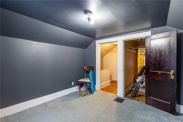 additional living space featuring lofted ceiling and carpet flooring