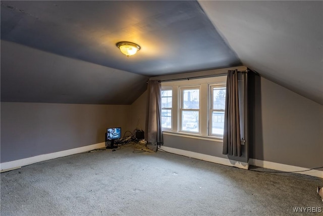 bonus room with lofted ceiling and carpet flooring