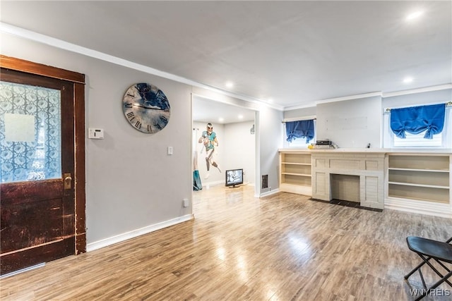 living room featuring wood-type flooring, a brick fireplace, and crown molding