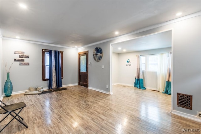 unfurnished living room with ornamental molding and light hardwood / wood-style floors