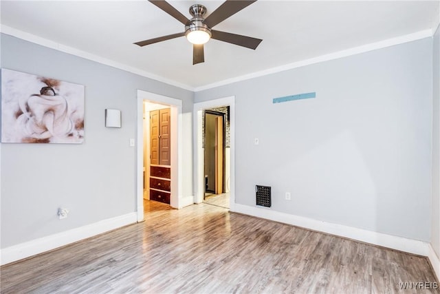 spare room with crown molding, wood-type flooring, and ceiling fan